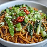 Silky wheat noodles coated in a zesty ginger-scallion sauce, topped with fresh baby bok choy and snap peas.  