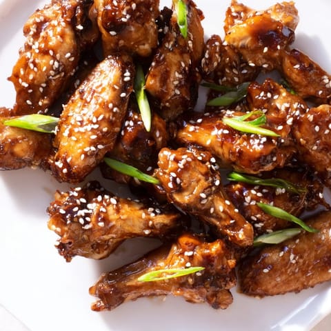 Freshly sliced green onions and toasted sesame seeds garnish these sticky chicken wings.