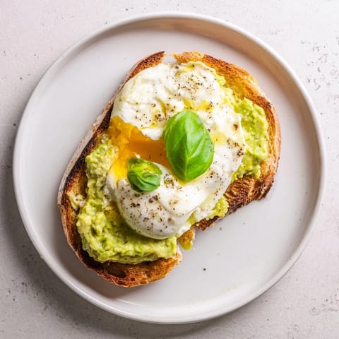 Golden melted mozzarella blankets a vibrant spread of creamy, lemony avocado on crisp, toasted sourdough in this savory Avocado Mozzarella Tartine.