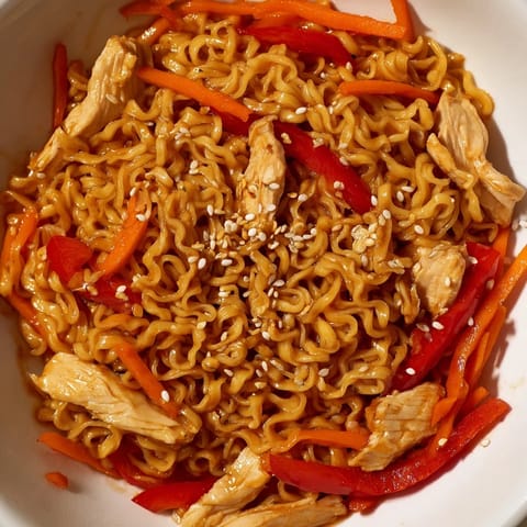 Tender chicken, crisp broccoli, and julienned carrots coat the glistening Spicy Ramen Stir-Fry noodles with a savory, aromatic sauce.