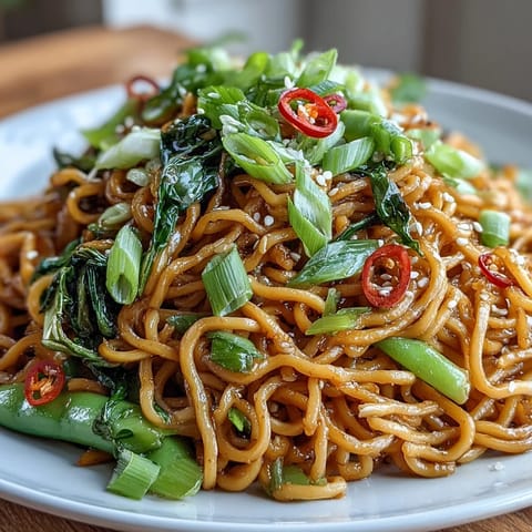 Vibrant Asian ginger scallion noodles tossed with sautéed greens in a savory, aromatic sauce.  