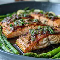 Garlic Butter Salmon with Asparagus, roasted to perfection, glistening with golden garlic butter sauce and lemon slices.