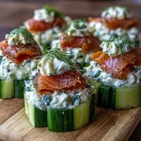 Crisp cucumber rounds topped with creamy dill-infused cheese and smoked salmon for an elegant, refreshing appetizer.  